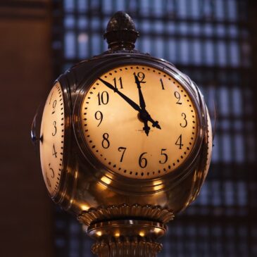 turned on brass-colored train station analog clock